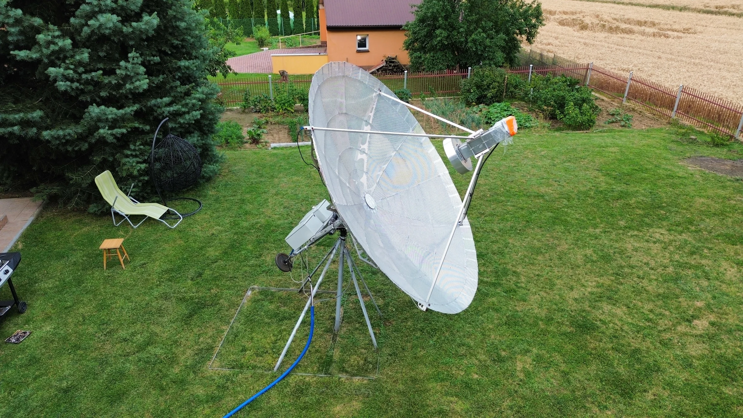 Duża antena paraboliczna na stalowej konstrukcji, sfotografowana z drona.