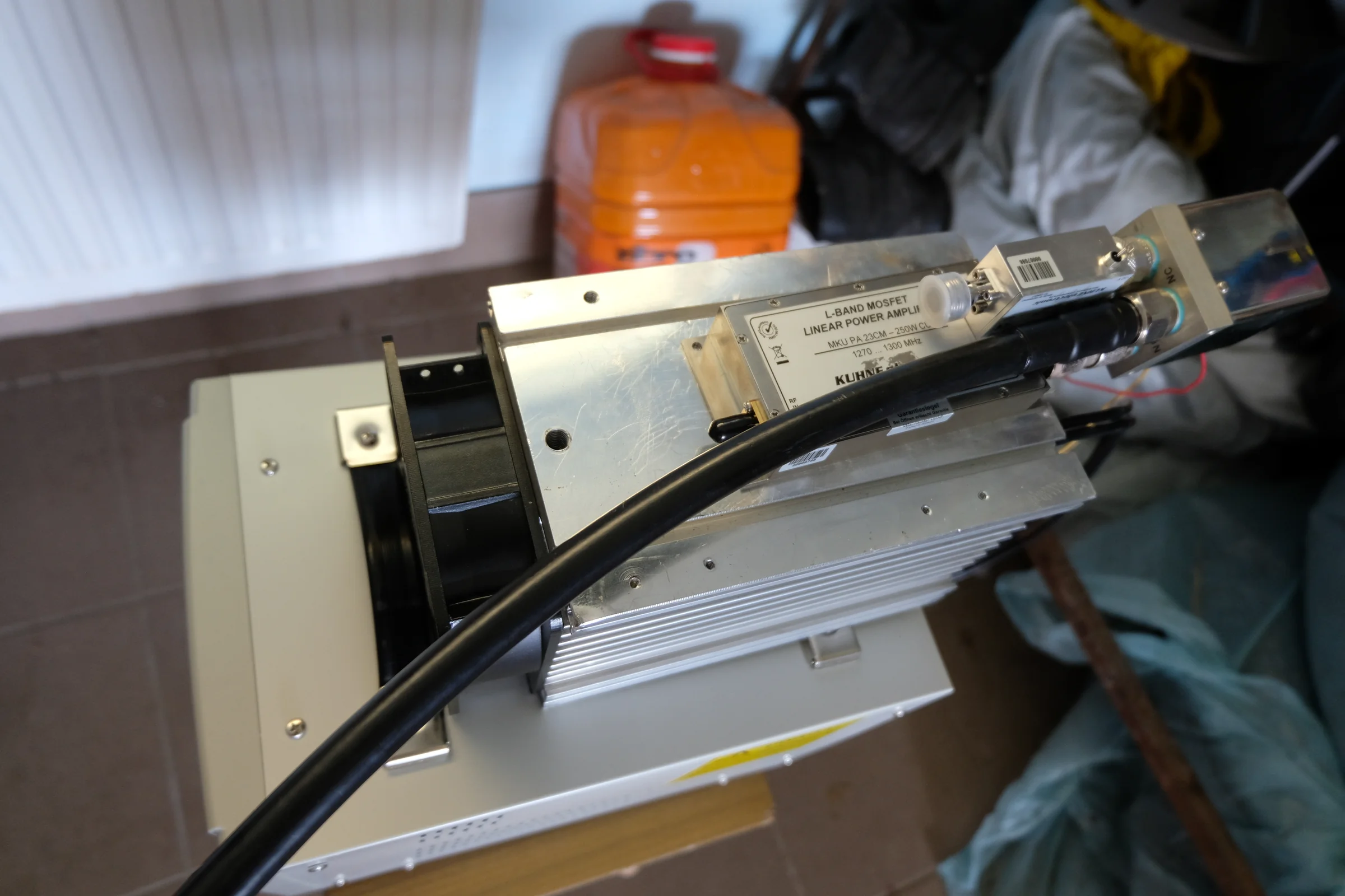 Otwarte metalowe urządzenie z przewodami i elementami elektronicznymi.