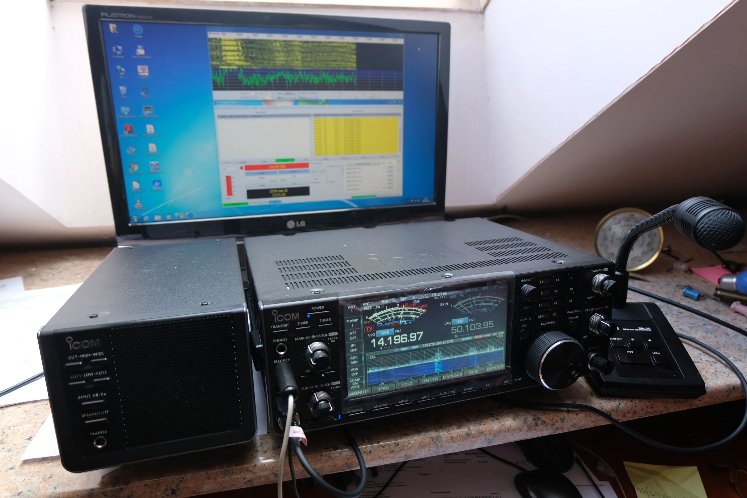 Radiostacja ICOM, mikrofon i laptop z programem radiowym na biurku.