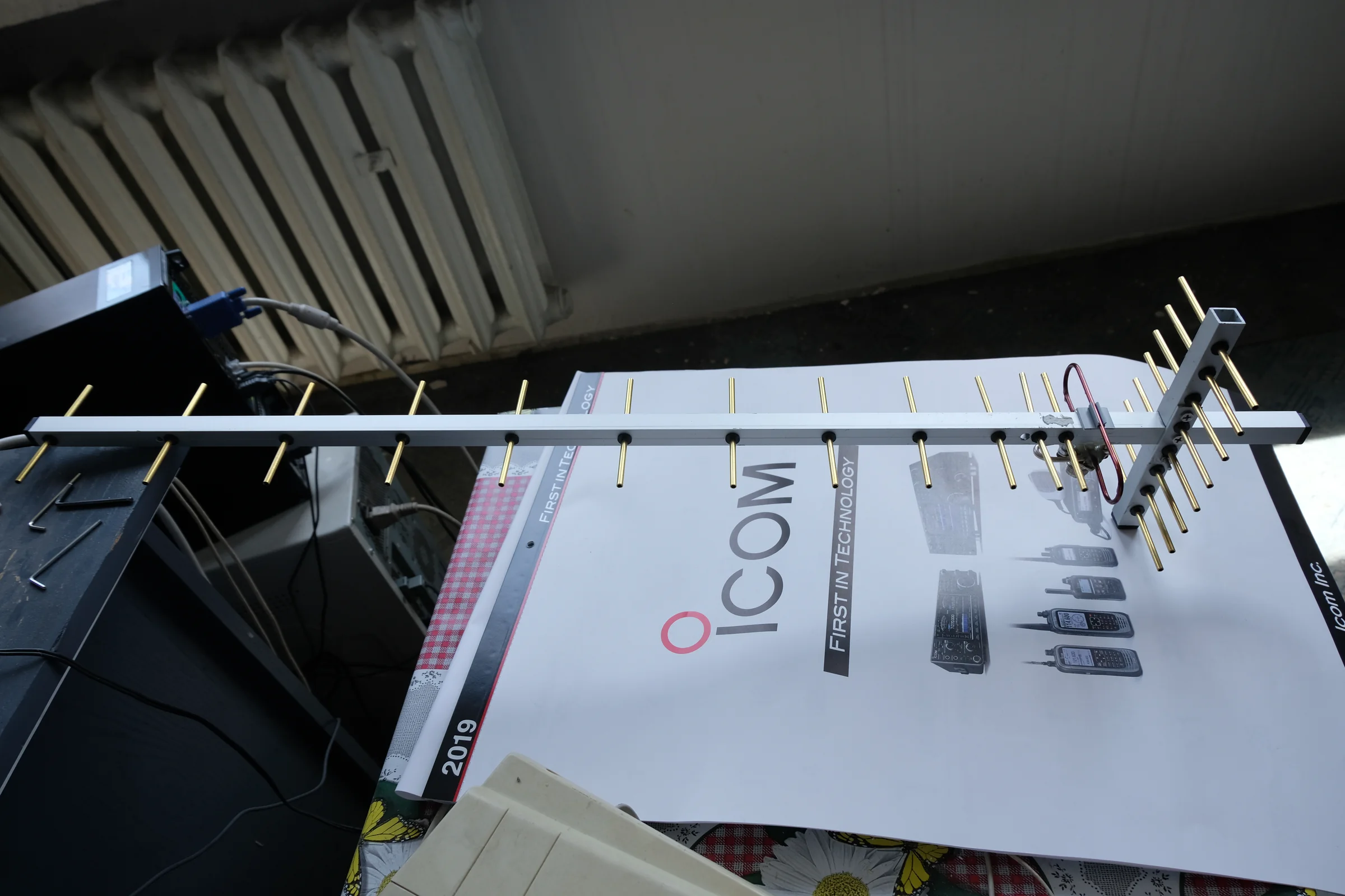 Niewielka antena Yagi leży na stole obok materiałów ICOM.